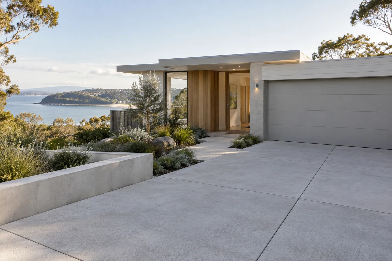 Connected concrete driveway, entry path and garden edges at an Australian home